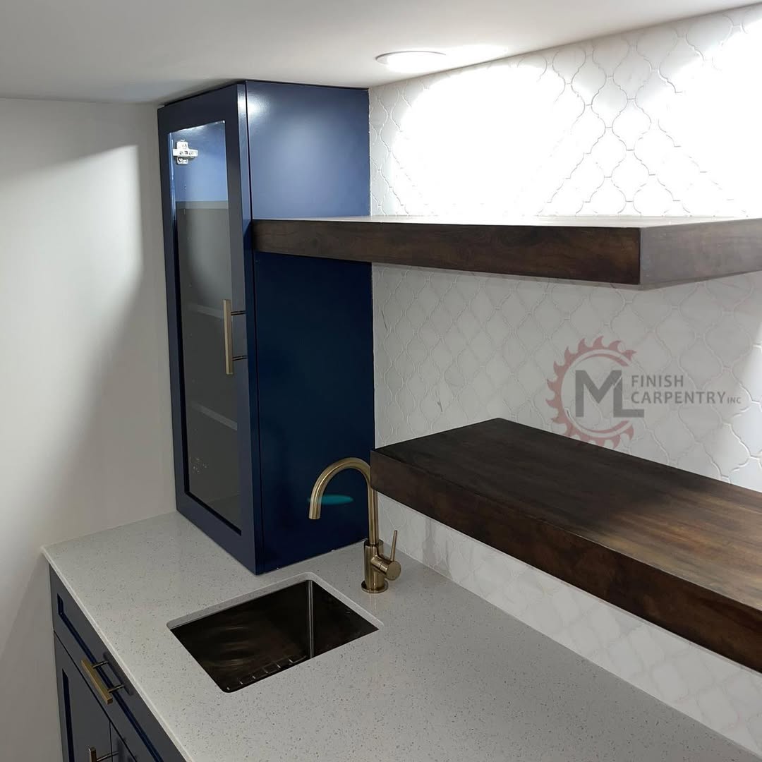 Detail of the wet bar showing floating wood shelves, arabesque tile and a brass faucet over the bar sink