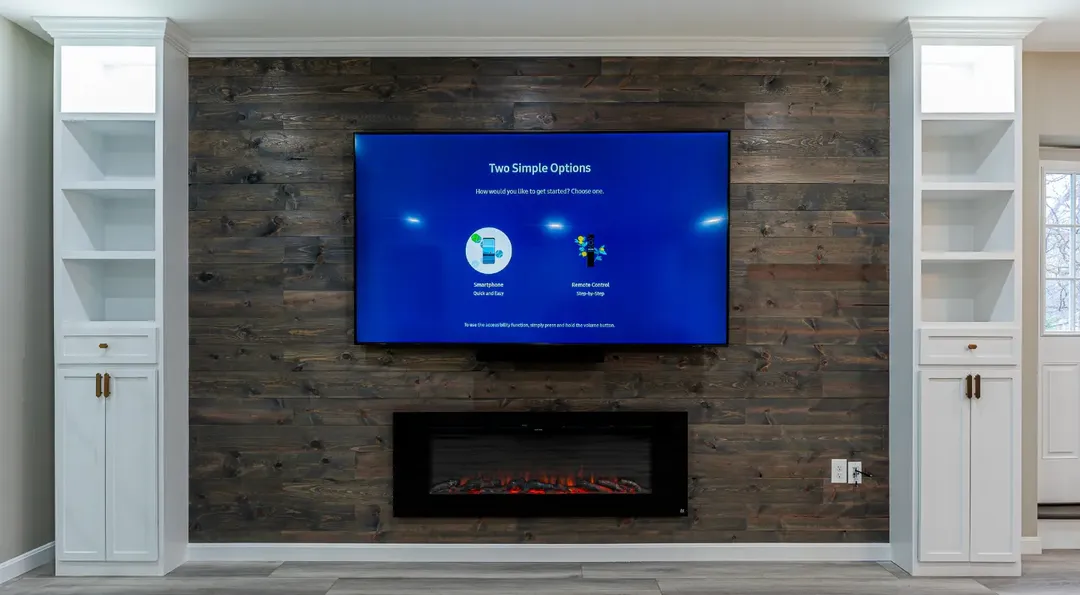 Basement media wall with reclaimed-look plank feature wall, linear fireplace and flanking white cabinetry with open shelving